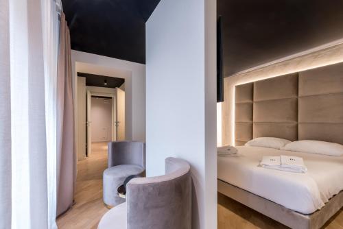 una camera con un grande letto e una sedia di Brera Premium Apartment near Duomo Wifi a Milano