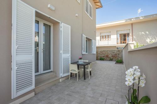 a patio of a house with a table and chairs at Prima dell'Elba Family Apartments in Piombino