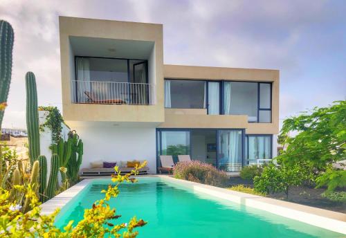 a house with a swimming pool in front of a house at Villa Sama in Punta de Mujeres