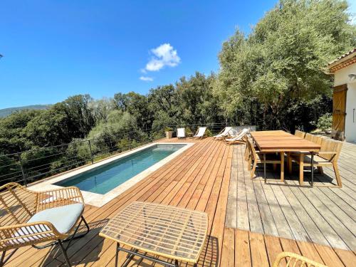 une terrasse avec une table et des chaises ainsi qu'une piscine dans l'établissement Villa piscine Sagone Paradise avec magnifique vue mer, à Sagone