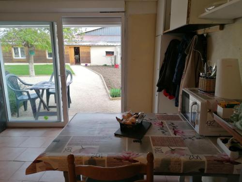 a kitchen with a table and a door to a yard at Chambre d'hôtes in Bleigny-le-Carreau