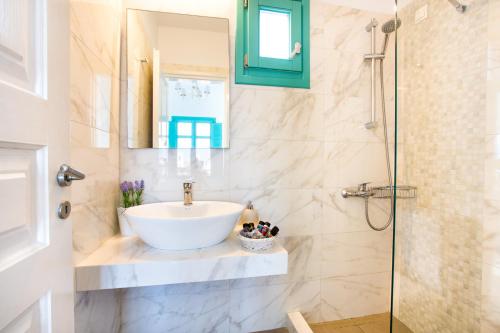 a bathroom with a sink and a shower at Hotel Odysseus in Chora Folegandros