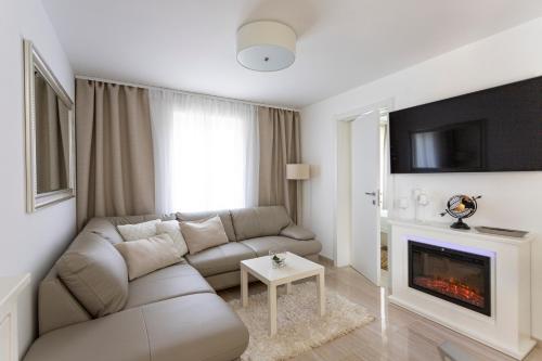 a living room with a couch and a fireplace at Luxury Mantinela Apartment in Malinska