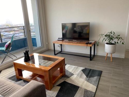 ein Wohnzimmer mit einem TV und einem Couchtisch in der Unterkunft Departamento Amoblado con excelente ubicación in Concepción