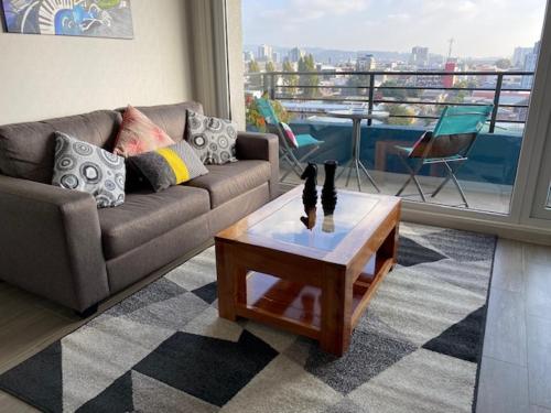 a living room with a couch and a coffee table at Departamento Amoblado con excelente ubicación in Concepción
