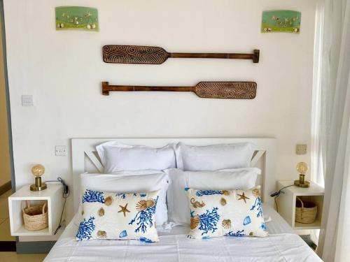 a bedroom with a bed with blue and white pillows at Hibiscus Penthouse vue mer 2 chambres in Trou aux Biches