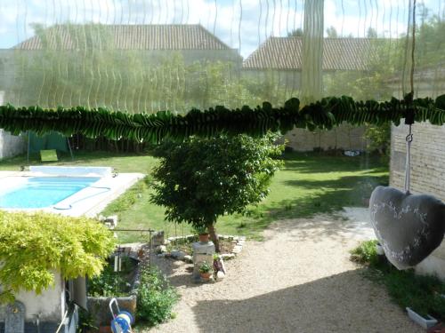 vistas a un patio con un árbol y una piscina en Le Clos Notre Dame B&B, en Mareuil