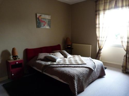 1 dormitorio con cama con almohadas y ventana en Le Clos Notre Dame B&B, en Mareuil