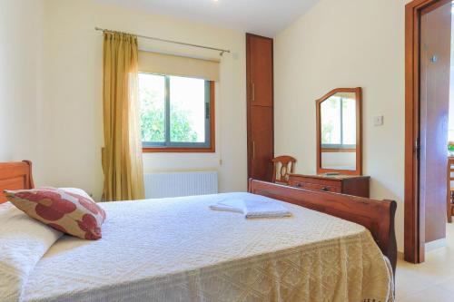 a bedroom with a bed and a mirror at Villa Styliani in Droushia
