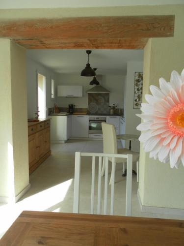 a kitchen with a table and a flower on the wall at Le Mas des Meras - Gite Côté mas in Lurs