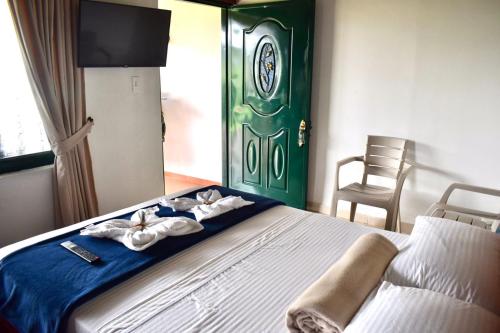a bedroom with a bed with a green door at El Portal De Don Luis in Guadalupe