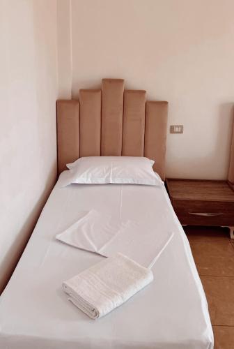 a large white bed with a towel on it at Hotel Nino in Dhërmi