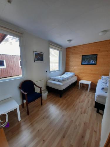 a room with two beds and a table and a chair at Rauðsdalur in Brjánslækur