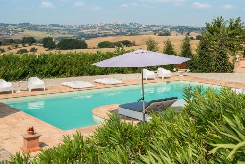 a swimming pool with an umbrella and two chairs at Relais Il Margarito in Montefano