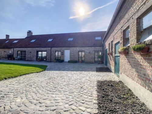 a brick building with a stone pathway next to it at Hoeve Langhof in Wenduine