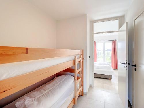 a bedroom with two bunk beds and a window at Hoeve Langhof in Wenduine
