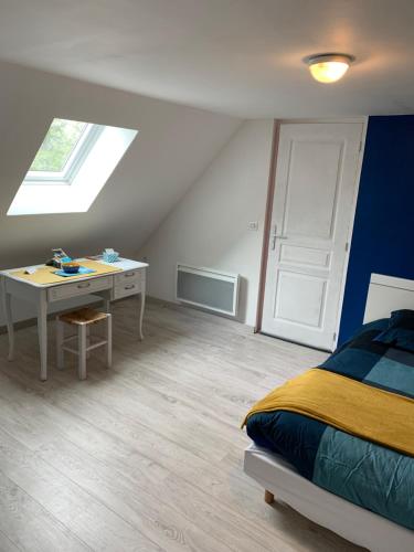 um quarto com uma cama, uma secretária e uma janela em Le Mesnil Normand em Fort-Moville