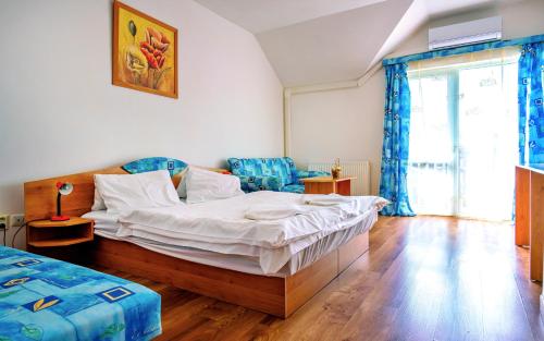a bedroom with a bed and two chairs in it at PENZIÓN QUATRO II 250m od kúpaliska in Podhájska