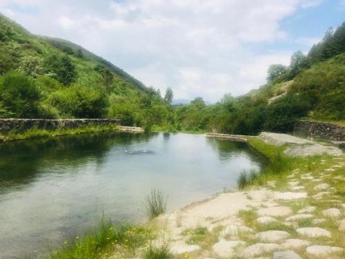 a river in the middle of a valley at Janelas da Cabreira in Campos