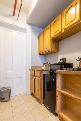 a kitchen with wooden cabinets and a black dishwasher at The Central Park North in New York