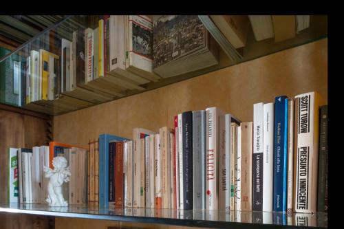 a book shelf filled with lots of books at Hotel 99 Cannelle in LʼAquila