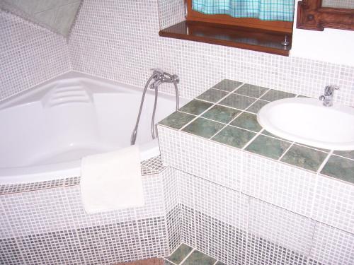 a bathroom with a white tub and a sink at Černý důl 18 in Černý Dŭl