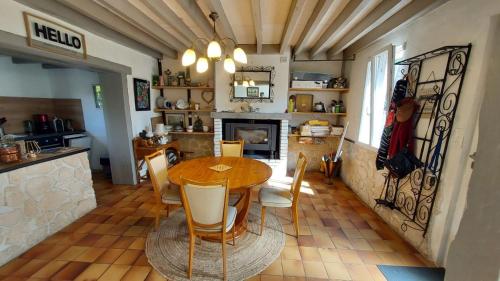 une cuisine et une salle à manger avec une table et des chaises dans l'établissement La maison aux oiseaux, à Heudreville-sur-Eure