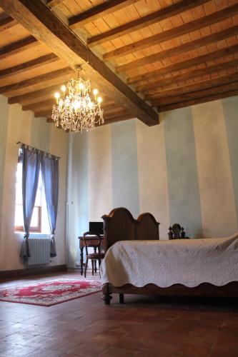 a bedroom with a large bed and a chandelier at Room and Breakfast Torre in Felino