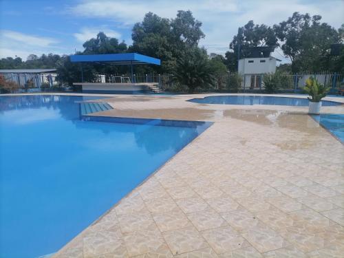 a swimming pool with blue water in a yard at Hotel campestre la Maria in Villavicencio