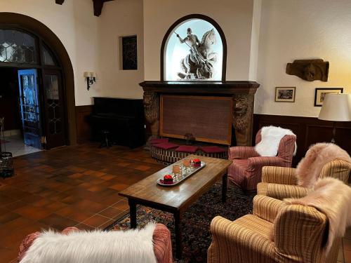 ein Wohnzimmer mit einem Tisch und einem Klavier in der Unterkunft Hotel zum Ritter St. Georg in Heidelberg