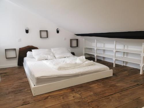 Cama blanca en una habitación con estanterías blancas en EMBATA, en Ustaritz