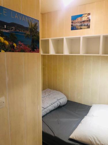 Cette petite chambre comprend un lit et des étagères. dans l'établissement Horizon 5 pied dans l'eau, au Lavandou