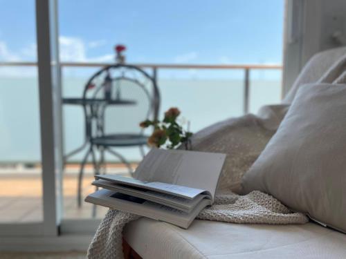 ein Buch auf einer Couch mit Laptop drauf in der Unterkunft Unik Vacation Rovira i Virgili in Tarragona