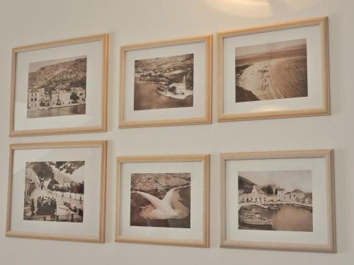 a group of framed pictures on a wall at Apartmani Robert in Bol