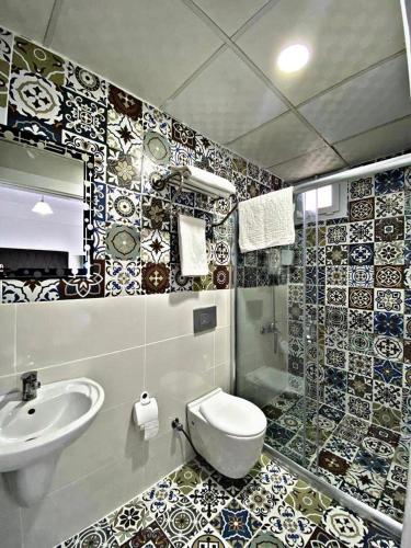 a bathroom with a toilet and a sink at Lotus Otel in Tasucu
