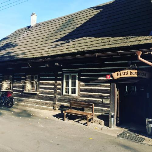 a wooden building with a bench in front of it at Pension Stará hospoda in Dobřív