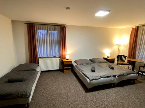 a bedroom with two beds and a table and chairs at Pension Stará hospoda in Dobřív