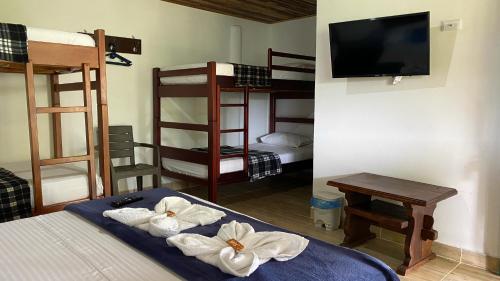 a room with bunk beds and a television and towels at El Portal De Don Luis in Guadalupe