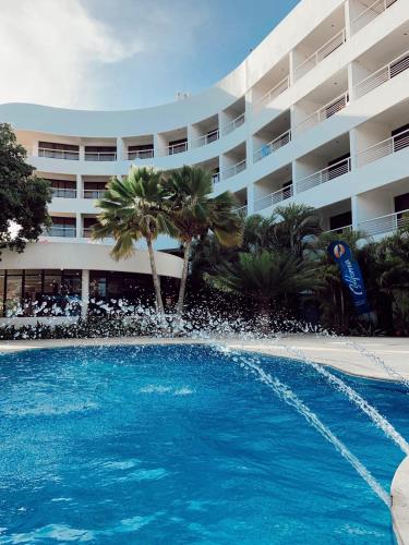 a large swimming pool in front of a hotel at Hotel California Playa El Yaque in El Yaque