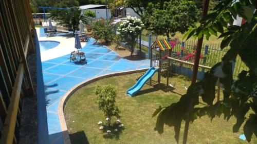 a playground with a slide next to a pool at Hotel campestre la Maria in Villavicencio