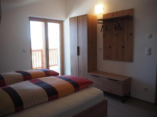 sypialnia z dwoma łóżkami i oknem w obiekcie Ebner Appartements w mieście Aldino