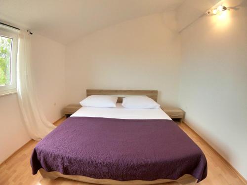 a bedroom with a large bed with a purple blanket at Lifestyle apartment Podstrana in Podstrana