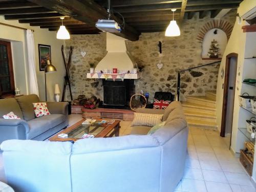 sala de estar con sofás y chimenea en Les Ecuries, traditional stone farmhouse with pool en Marquixanes