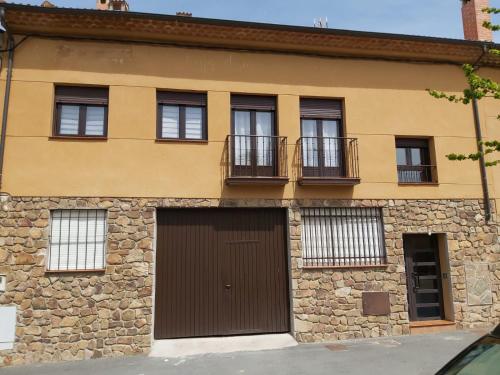 a building with windows and a brown garage at CORRAL DEL DUQUE II in San Cristóbal de Segovia