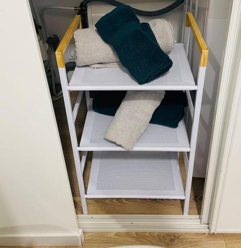 - une étagère blanche avec des serviettes dans un placard dans l'établissement Le Studieux Abbevillois, à Abbeville