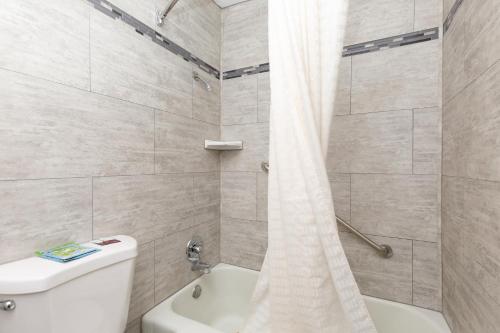 a bathroom with a white toilet and a shower at Stay Express Inn Elko in Elko