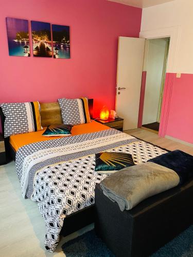 a bedroom with two beds and a red wall at Bien-être-Au-calme et parking gratuit in Seraing
