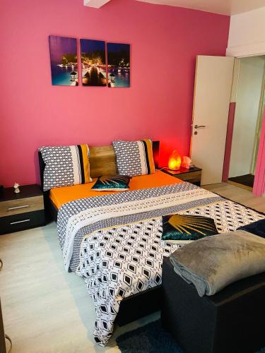 a bedroom with two beds and a pink wall at Bien-être-Au-calme et parking gratuit in Seraing