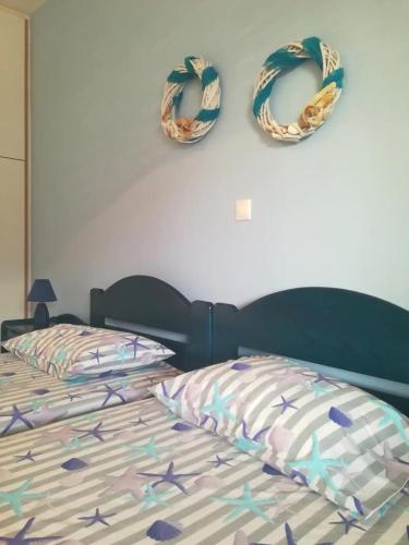 a bedroom with a bed with two wreaths on the wall at Andros Eco Home in Gavrion