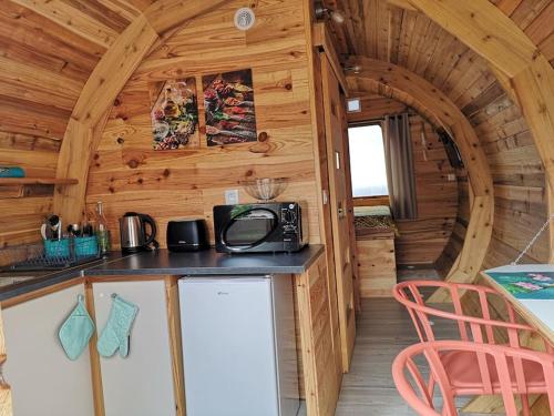 eine Küche in einer Holzhütte mit einer Arbeitsplatte in der Unterkunft Le Myranoa, bungalow/tonneau in Saint-Pierre